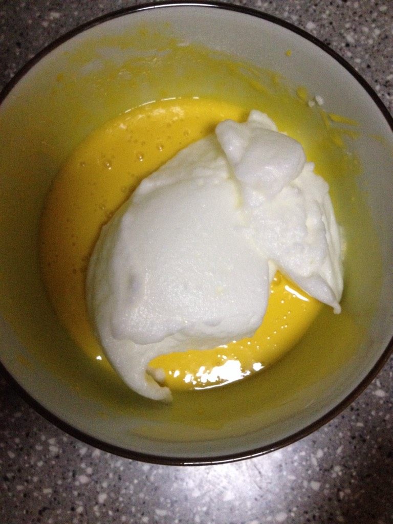 电饭煲蛋糕,然后将发好的蛋清分两次加入蛋黄面糊中，由下而上进行搅拌