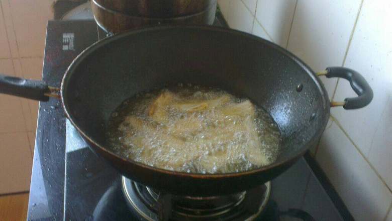 自制(糖醋带鱼),锅内放油烧热，倒入带鱼炸至金黄色；