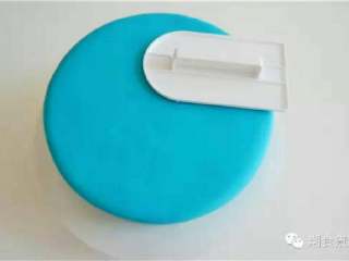 可爱到不忍下口的冰雪奇缘3D蛋糕|翻糖蛋糕教学,擀平蓝色翻糖并平铺在蛋糕上，再用抹平器将其均匀地抹平；