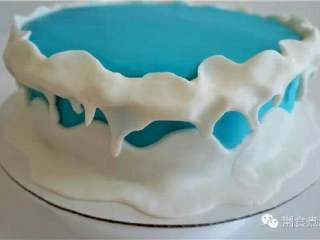 可爱到不忍下口的冰雪奇缘3D蛋糕|翻糖蛋糕教学,用白色翻糖制作成雪的形状铺在蓝色翻糖上，过程中灵活利用手指将其捏出雪融化的效果；