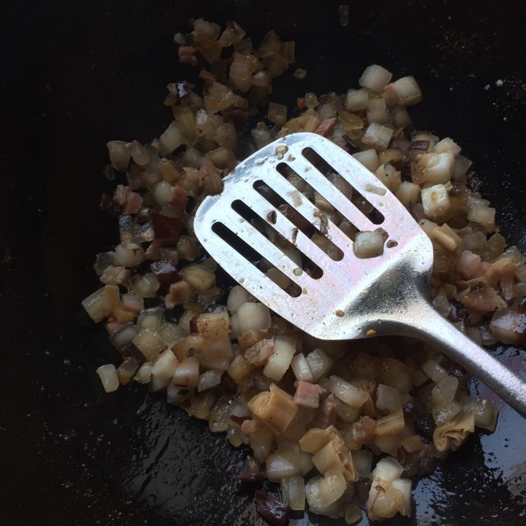 萝卜丝腊肉包子,如图先将腊肉中的油脂炒出，多余油脂倒出不要