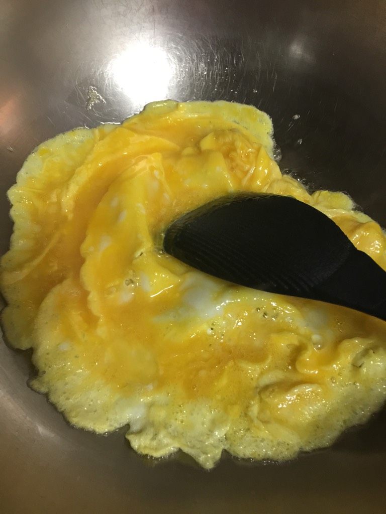 韭菜炒蛋,如图起油锅，至5分热倒入蛋液，蛋液稍微凝固后用铲子不断翻炒，至全部凝固后盛起备用；