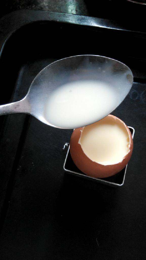 原蛋布丁,用一个模型把鸡蛋固定好在烤盘里。然后倒入牛奶蛋液。
