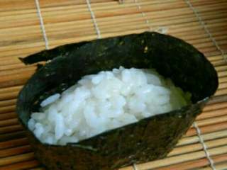 日式军舰寿司,海苔剪成适当大小，围绕饭团一周，封口用米饭沾紧。