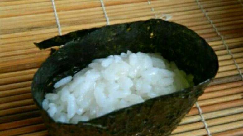 日式军舰寿司,海苔剪成适当大小，围绕饭团一周，封口用米饭沾紧。