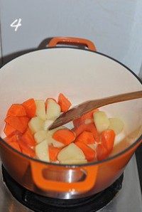 红咖喱鸡肉炖杂蔬,锅烧热放油，油热后倒入土豆和胡萝卜块，小火慢慢煸炒5分钟左右