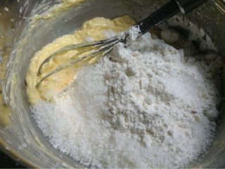 黄金椰丝球,如图再加入椰丝和低筋粉用手搅拌均匀再揉成面团