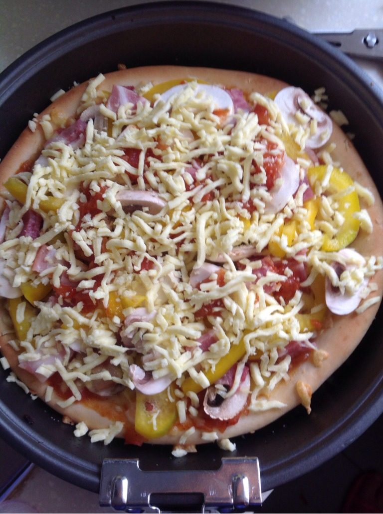 培根披萨,如图最后再铺满马苏里奶酪丝，放入200度上下火烤十分钟