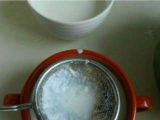 自制 老北京奶酪,牛奶倒入小碗中过滤下。