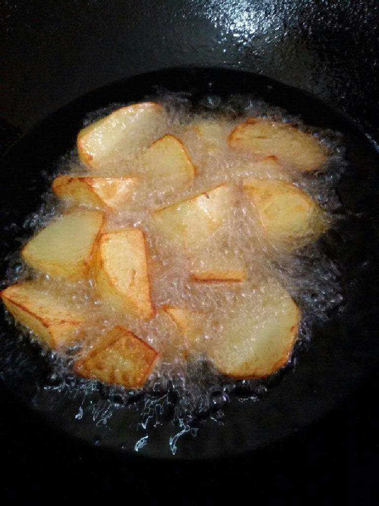 番茄胡萝卜土豆炖牛腩,锅加油烧热倒入切好土豆炸到金黄捞出备用。