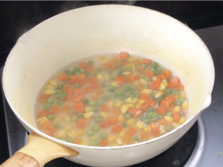 五彩虾仁,起锅烧开水，放入胡萝卜、青豆和玉米粒煮至断生