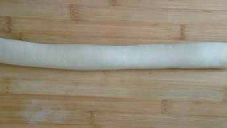 翡翠饺子,白色的面团搓成一个圆长条。