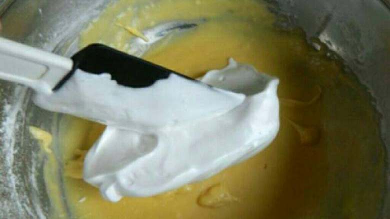 香蕉黄油蛋糕,把蛋白霜分三次放入蛋黄面糊中翻拌均匀。