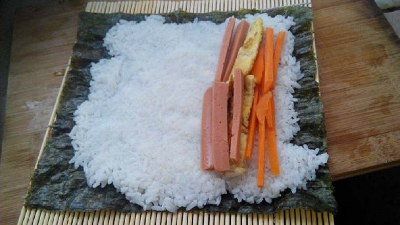 食寿司卷——剩米饭的华丽转身, 在米饭上铺上鸡蛋皮、胡萝卜、火腿肠