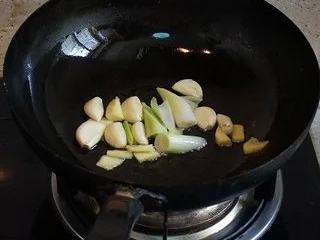 干锅牛蛙,把葱姜蒜下到油锅内煸香。