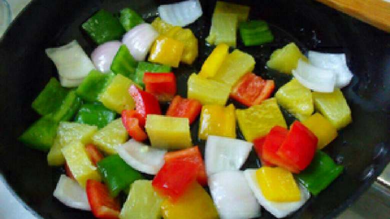 菠萝咕噜肉,锅里放三分之一汤匙食用油，炒一下彩椒和洋葱片，炒均匀。