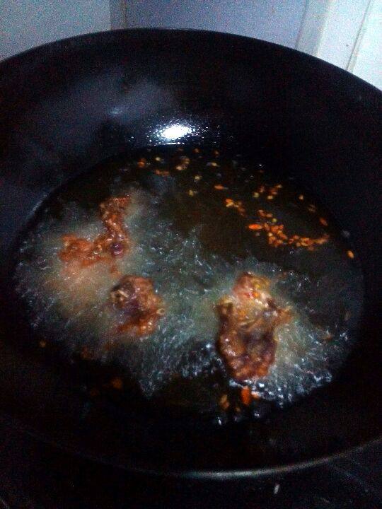 自制炸鸡骨架,锅中加入适量的油， 油热后，放入腌好的鸡骨架，炸至变色，捞出。