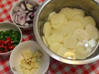 干锅土豆片,土豆切片后过水清除表面的淀粉、洋葱切块、青红辣椒切段、蒜切片。