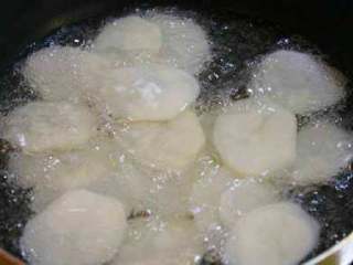 干锅土豆片, 锅内倒入油，滑温六层热的时候，下入土豆片。炸制表面微黄时捞出备用。