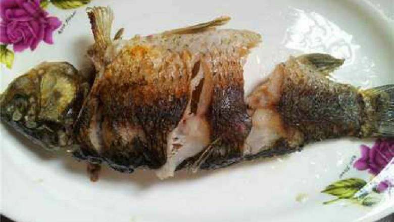 红烧鲫鱼,锅里放适量油，待油稍热拎起鱼放下去煎至两面金黄后拿出来放盘子里。