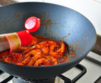 茄汁油焖大虾,加入少许开水和糖，翻炒均匀，盖上锅盖，保持大火稍焖片刻，至汤汁收浓