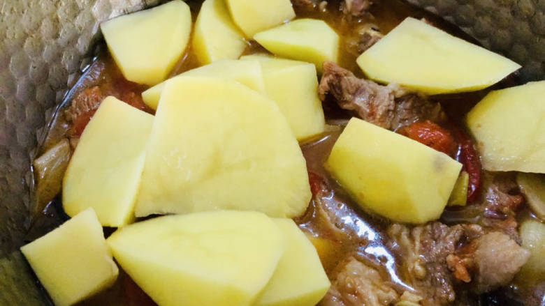 红焖牛肉煲,待牛肉烧至差不多时放入土豆，继续烧至土豆软烂即可。