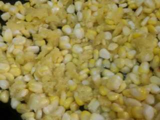 椒盐玉米粒,锅加适量油，烧至七，八成热倒入搅拌好的玉米粒，稍煎一会再翻动划散。