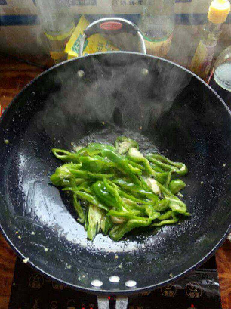 青椒黄瓜炒肉,热锅放油把辣椒蒜头放进去炒5分熟