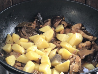 土豆香菇焖鸡,半小时后放入土豆，少许盐和胡椒粉拌匀后继续焖5分钟