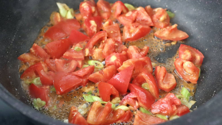 番茄金汤饺子,加入番茄块，大火快速翻炒至变软出汤汁。