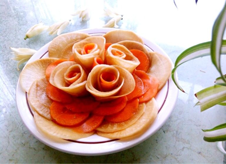 糖醋玫瑰,如图花做好后,其他圆片切成半圆摆成花形,中间花心用胡萝卜