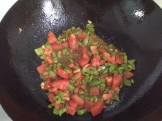 妈妈风味茄子,将茄子出锅，锅内留底油，油热后放入大蒜粒爆香后，依次放入菜椒丁、番茄丁。