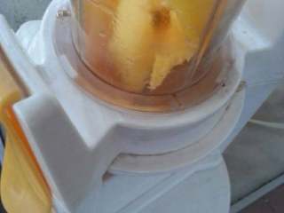 芒果酱,一半倒入料理机中搅拌。