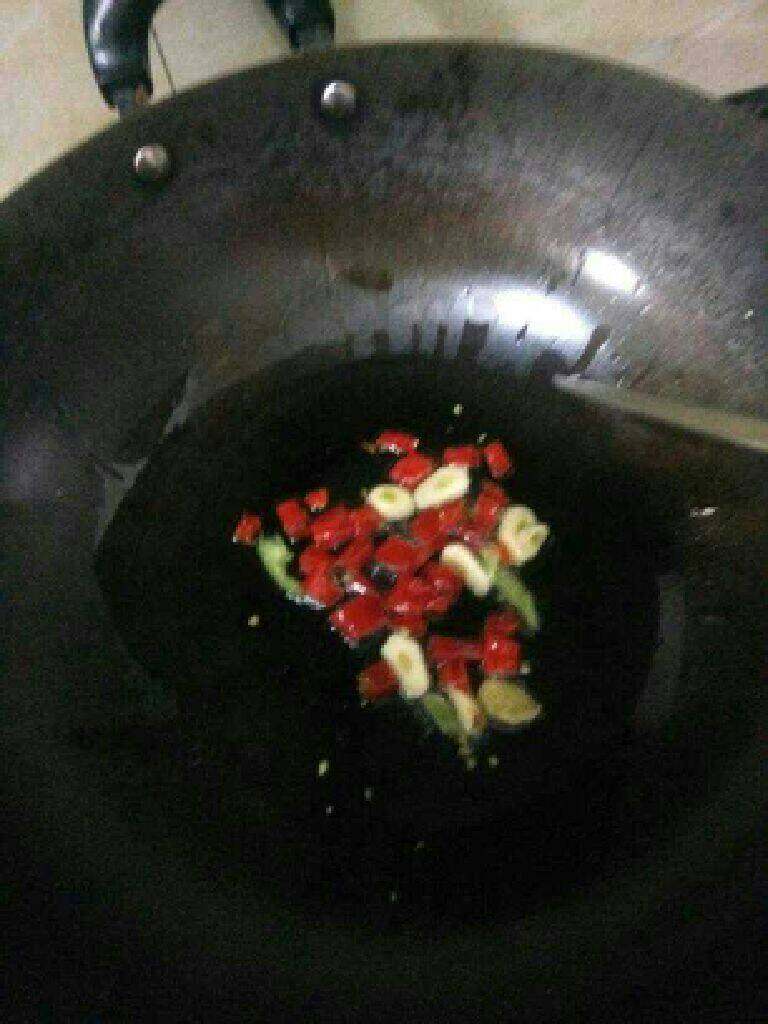 青椒鱿鱼丝,把蒜头和辣椒放入烧至七成热的油内炒香；