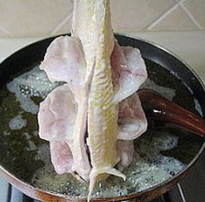 糖醋黄鱼,下八成热的油锅炸，先用手拿着鱼尾巴，用勺子将油缓慢的浇在鱼两边的花刀上