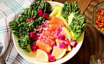 鲑鱼火龙果沙拉,将圆生菜摆在最下面，上面摆上菊花菜、三文鱼、柠檬、火龙果，然后把沙拉汁浇上即可食用