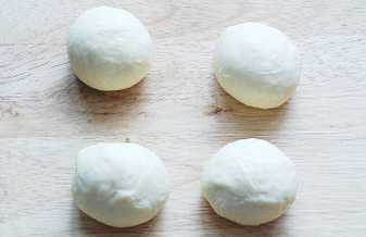 杏仁豆沙面包,取出面团轻轻按压排气，分成每个45g左右的面团，滚圆盖保鲜膜松弛15分钟；