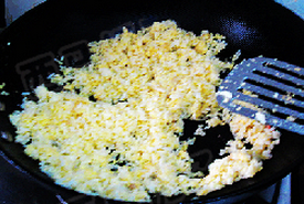 虾仁菠萝焗饭,另起锅，注入油，下入拌上蛋液的米饭，小火炒制，蛋液凝固的均匀粘在米饭上