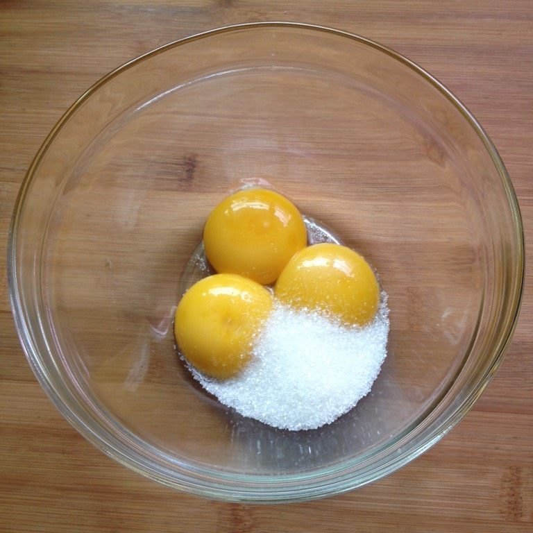 奶油杯子蛋糕,分离蛋黄和蛋白，蛋黄中加入20克细砂糖搅拌至糖融化