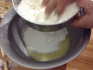 芝麻核桃桃酥,筛入面粉和小苏打泡打粉，搅拌均匀，再加入核桃仁，拌合成面团