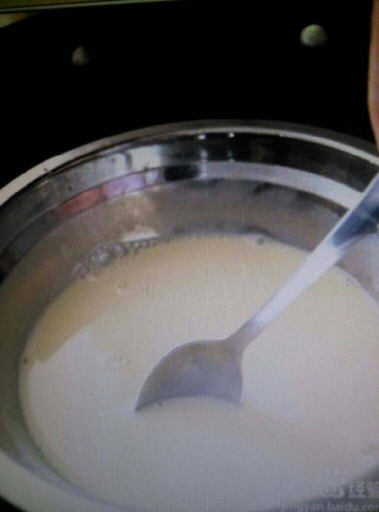 鸡蛋牛奶布丁,将上一步的碗放入热水里，不停的搅拌，让QQ糖慢慢的融化，用的葡萄味的QQ糖，所以做出的布丁还有葡萄味的味道。