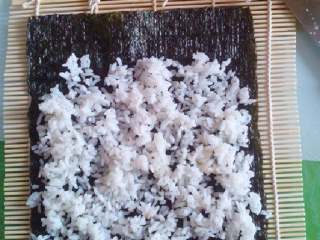 自制寿司,把之前拌好的大米铺上一层