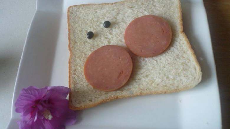 漂亮的早餐,面包片、<a style='color:red;display:inline-block;' href='/shicai/ 438'>火腿</a>片，2粒黑豆。