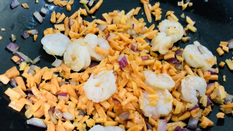 玉米虾仁蛋炒饭,倒入提前切好的胡萝卜丁快速翻炒均匀。