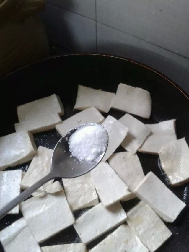孜然粉豆腐,如图。不粘锅放入油。油热放入豆腐煎