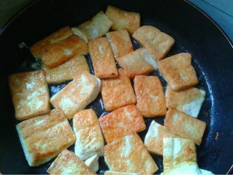 孜然粉豆腐,如图。煎至金黄翻过来继续煎。第二面一样撒少许盐和撒一点孜然粉
