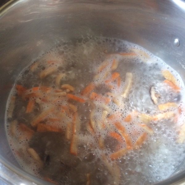 潮式虾粥,等饭煮开之后，还没熟时，把爆香的香菇、鱿鱼、豆干都放进锅里一起煮。