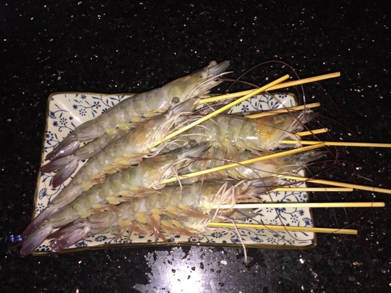 鲜虾手握寿司,从虾的颈部穿到尾部，弄熟之后，虾就是直的。
