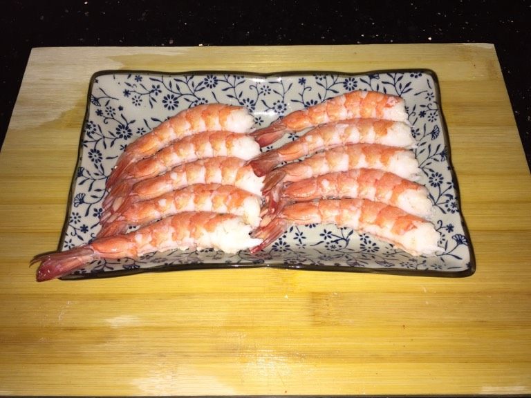 鲜虾手握寿司,小心掰壳。