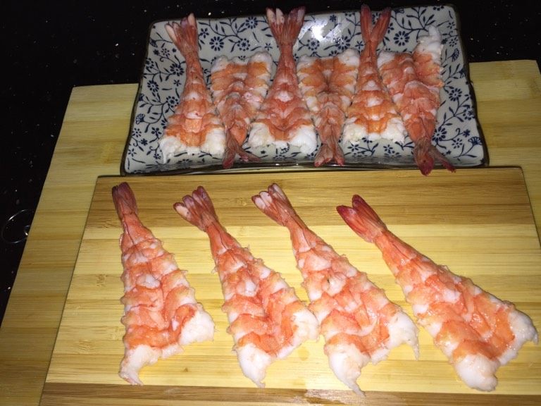 鲜虾手握寿司,从虾的腹部中间切开，注意把虾肠取出，不然会有很多沙粒。虾肠藏在虾背，腹部切开就能取出。